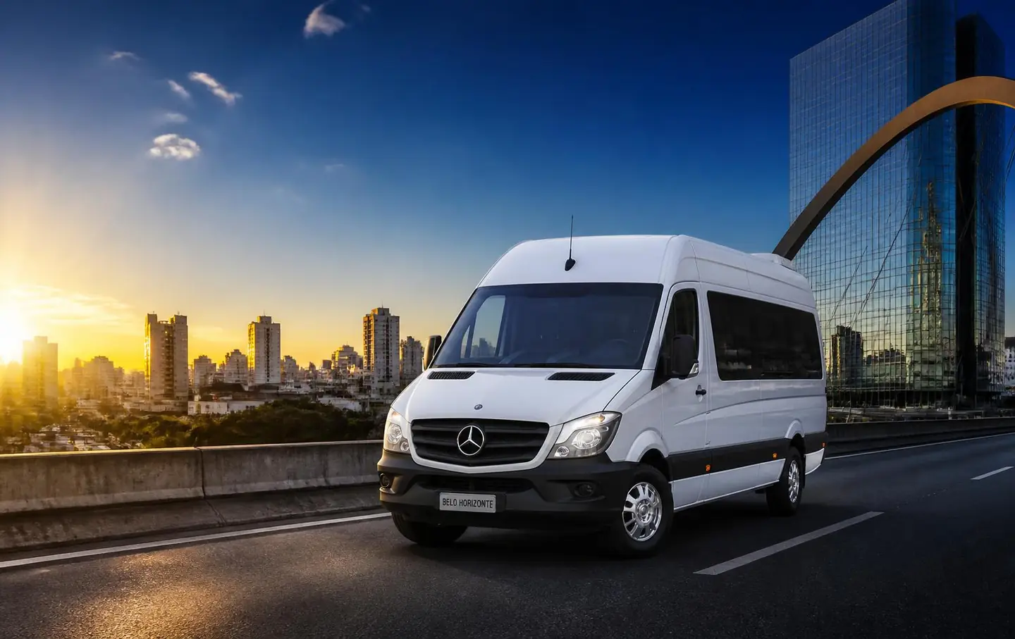 Van executiva branca da Vans Brasil em avenida de Belo Horizonte ao entardecer